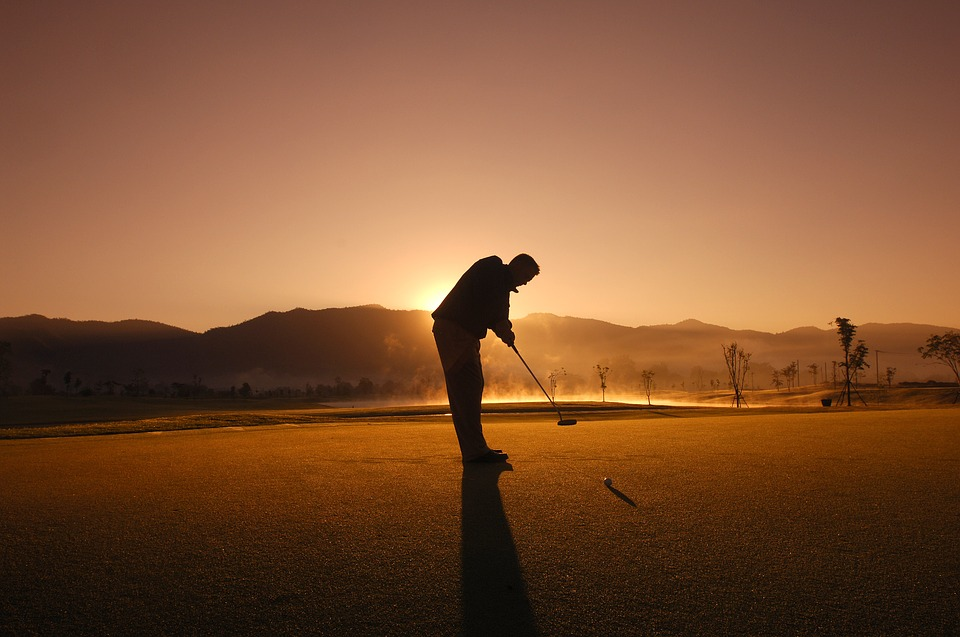 person doing golf during midnight sun 