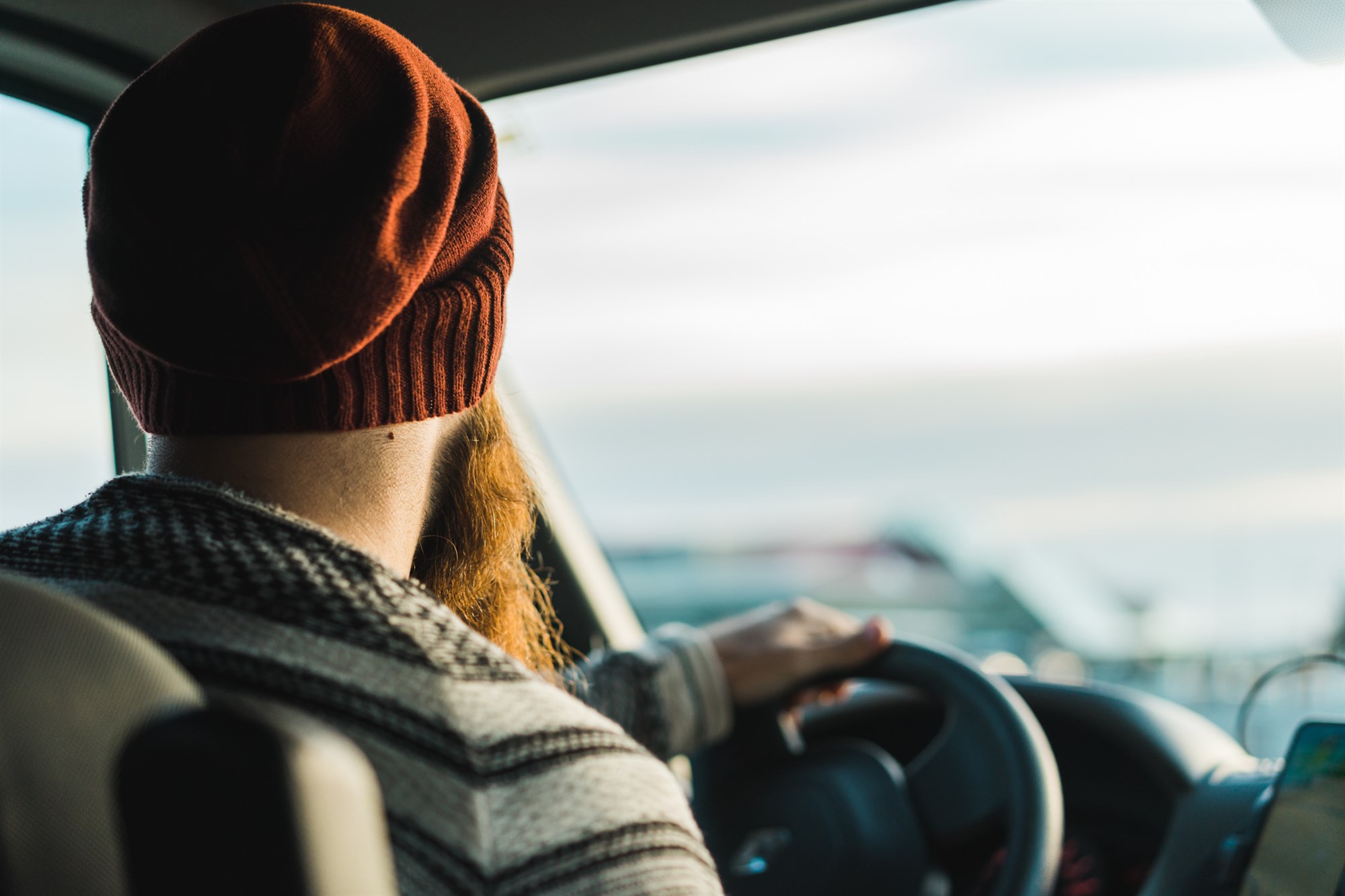 Prendre la route islandaise avec style et patience Conducteur concentré au volant de son camping car, prêt à affronter météo imprévisible, routes désertes et paysages qui vous arrêtent toutes les dix minutes.