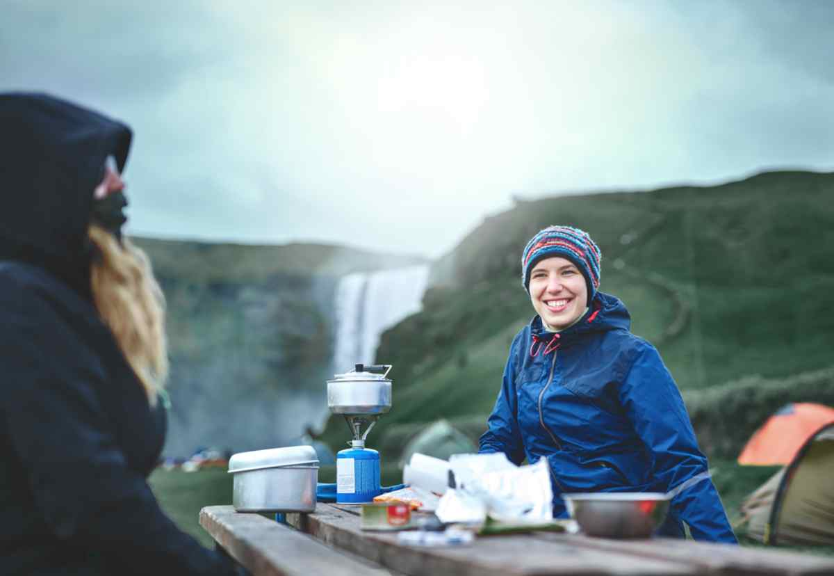 Voyageurs cuisinant dans un camping en Islande avec équipement outdoor expérience de van life et camping islandais