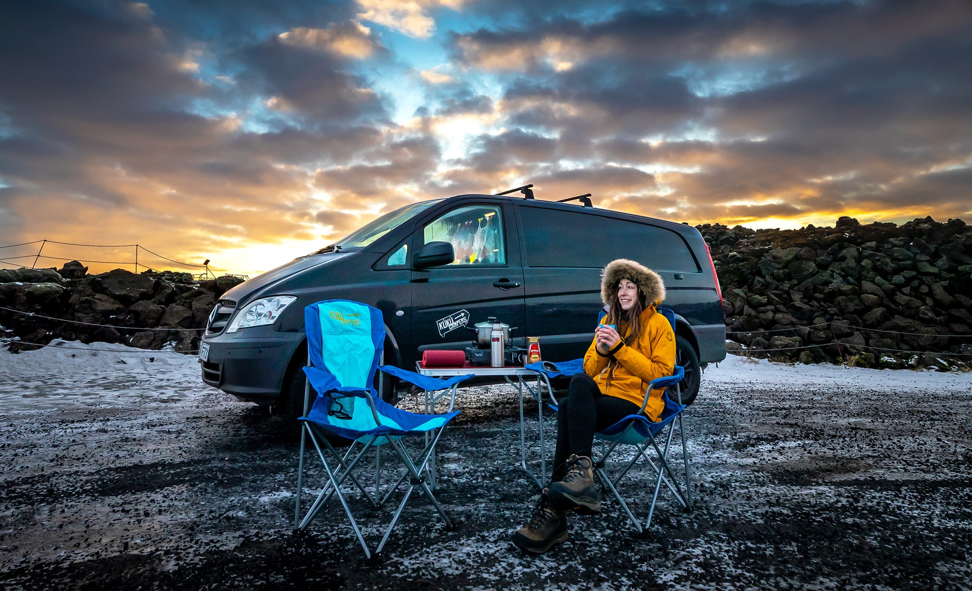 Voyageur profitant d’une pause café devant un van en Islande, moment typique d’un road trip en campervan.